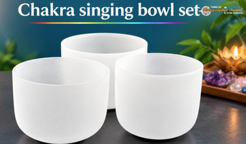 Set of seven chakra singing bowls arranged by size, with a mallet resting beside them